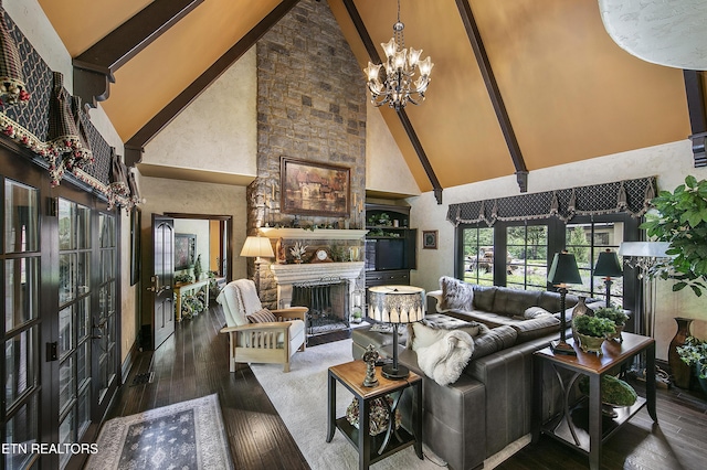 living area featuring high vaulted ceiling, a stone fireplace, hardwood / wood-style flooring, french doors, and an inviting chandelier