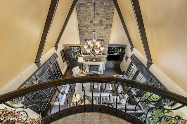 staircase with a chandelier, a fireplace, and a high ceiling