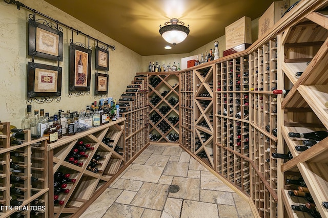 wine room with stone tile flooring and a textured wall