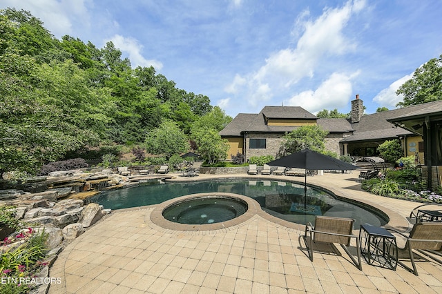 pool featuring a patio and an in ground hot tub