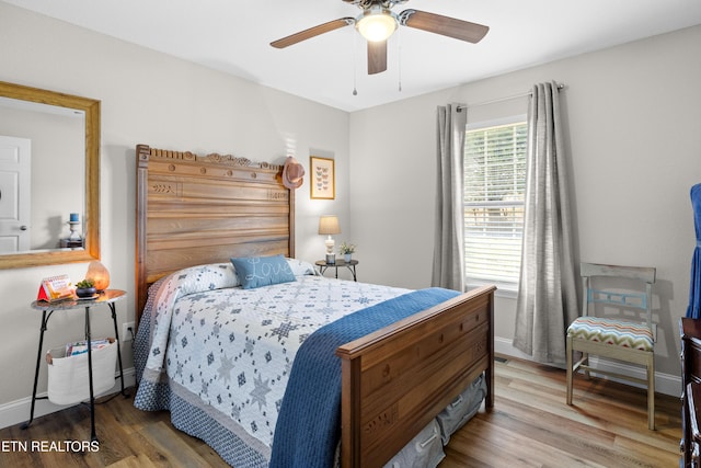 bedroom with a ceiling fan, baseboards, and wood finished floors