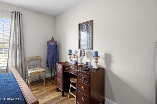 home office with light wood-style flooring and baseboards