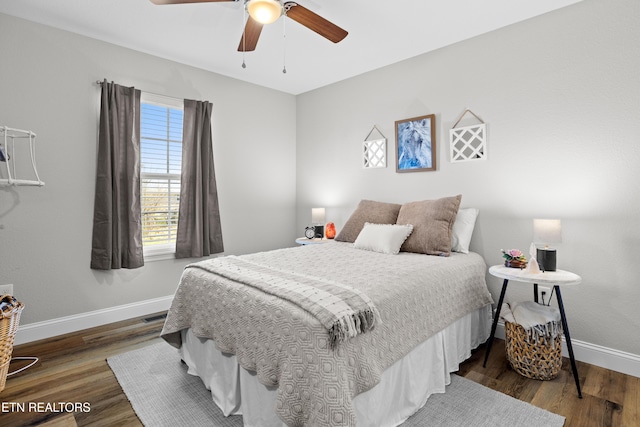 bedroom featuring dark wood-style flooring, ceiling fan, and baseboards