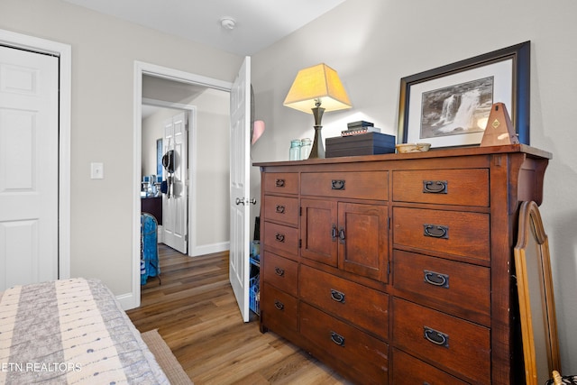 bedroom with light wood-style floors and baseboards