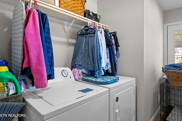 laundry area featuring laundry area, washer and clothes dryer, and a textured wall