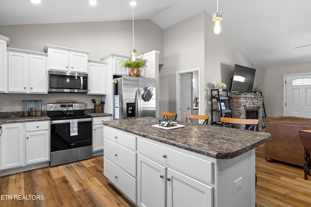 kitchen featuring stainless steel appliances, dark countertops, and a fireplace