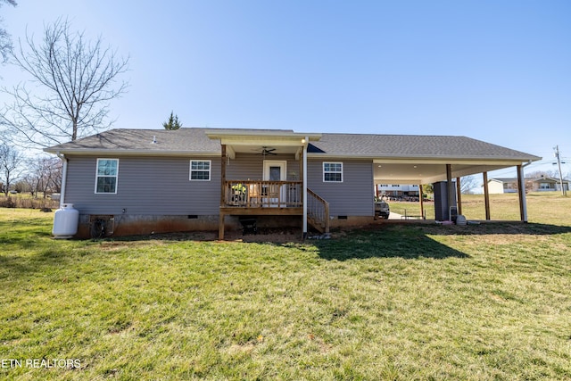 rear view of property with ceiling fan, a yard, an attached carport, and crawl space