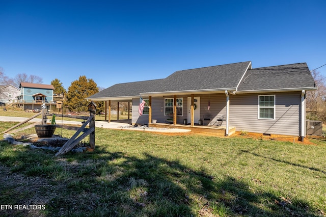 rear view of house with crawl space, roof with shingles, and a yard