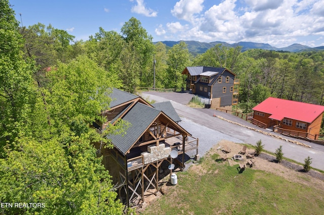 birds eye view of property featuring a mountain view and a wooded view