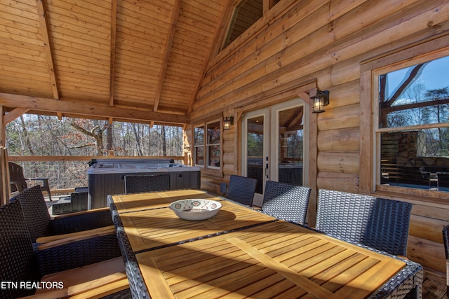 wooden terrace featuring outdoor dining area and a hot tub