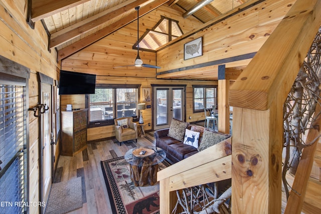 living area with high vaulted ceiling, wooden walls, wood ceiling, beam ceiling, and hardwood / wood-style floors