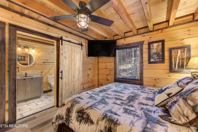 bedroom featuring wood ceiling, a barn door, wooden walls, and beamed ceiling