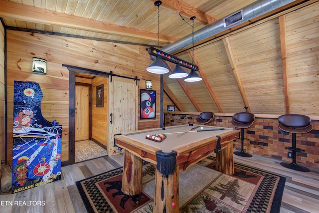 game room featuring a barn door, wooden walls, visible vents, wood ceiling, and wood finished floors