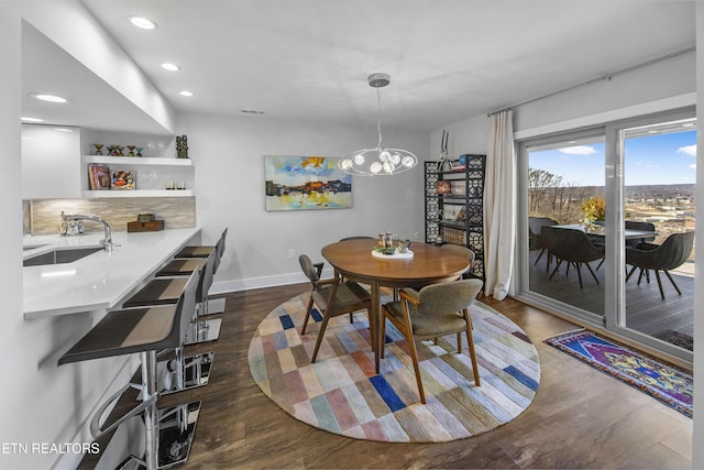 dining space with recessed lighting, a notable chandelier, dark wood finished floors, and baseboards