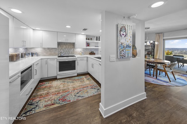 kitchen with white electric range oven, decorative backsplash, dark wood-style floors, stainless steel microwave, and light countertops