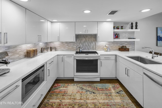 kitchen featuring open shelves, visible vents, white cabinetry, a sink, and white appliances