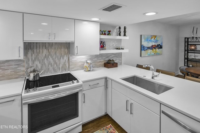 kitchen with light countertops, electric range, a sink, and visible vents