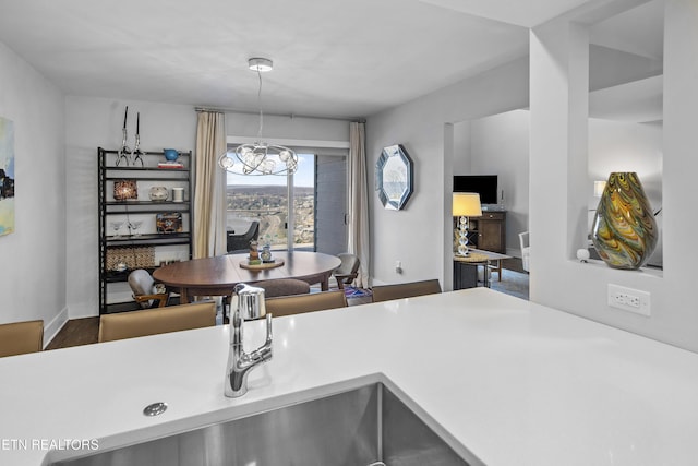 kitchen featuring a chandelier, light countertops, hanging light fixtures, and baseboards