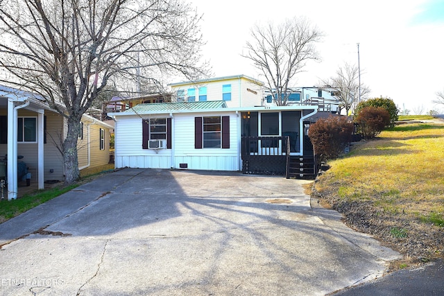 view of front of house featuring cooling unit, metal roof, and a front lawn