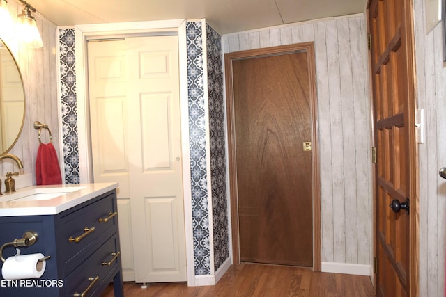 bathroom featuring vanity, baseboards, and wood finished floors