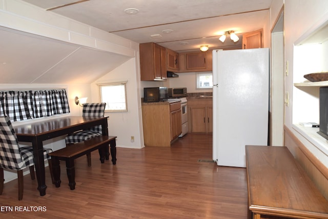 kitchen with brown cabinetry, white appliances, and dark wood finished floors