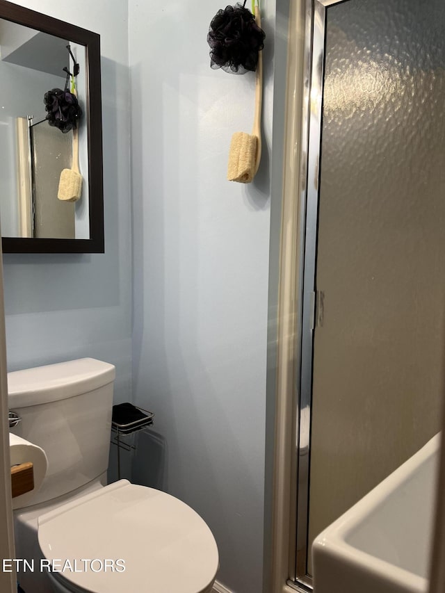 bathroom with a shower stall and toilet