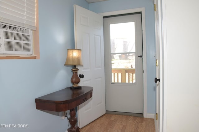 doorway with light wood-style flooring and cooling unit