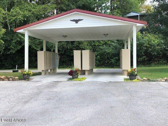 view of parking featuring driveway, mail area, and a carport