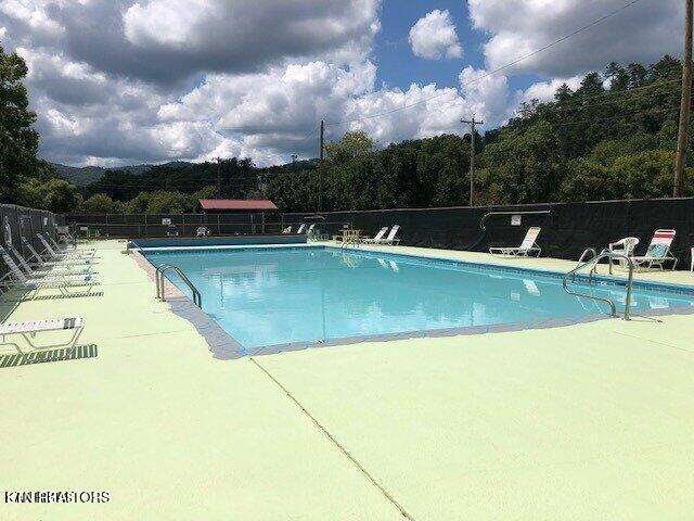 pool with a patio area and fence