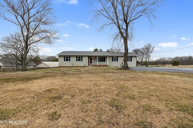 ranch-style house featuring fence and a front lawn