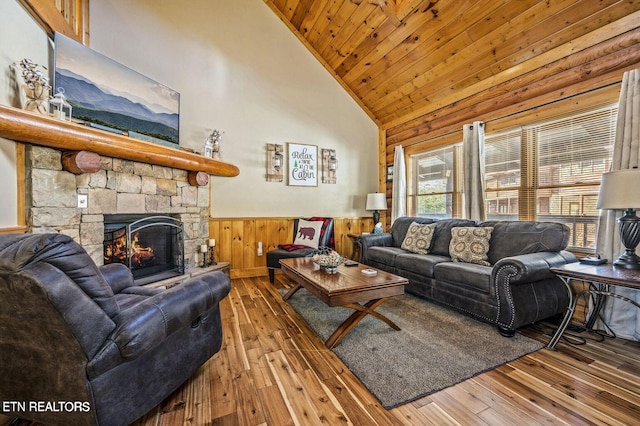 living area featuring high vaulted ceiling, wooden ceiling, a wainscoted wall, a fireplace, and hardwood / wood-style floors