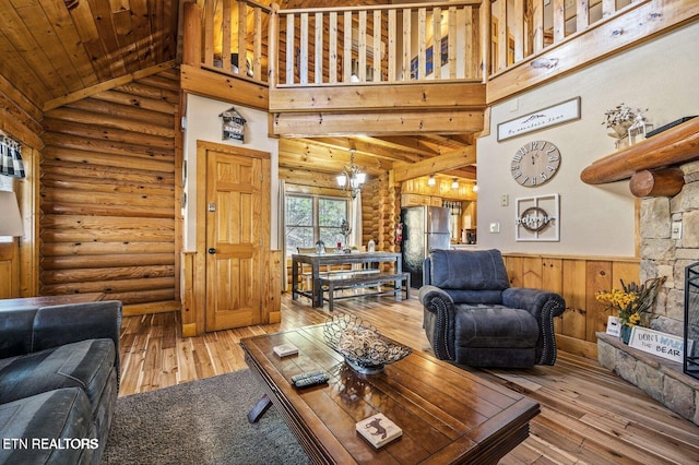 living area featuring a chandelier, high vaulted ceiling, a fireplace, and hardwood / wood-style flooring