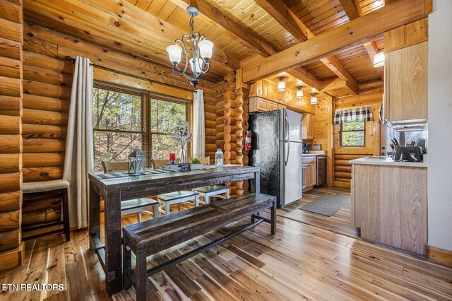 kitchen featuring wood ceiling, freestanding refrigerator, rustic walls, and hardwood / wood-style flooring