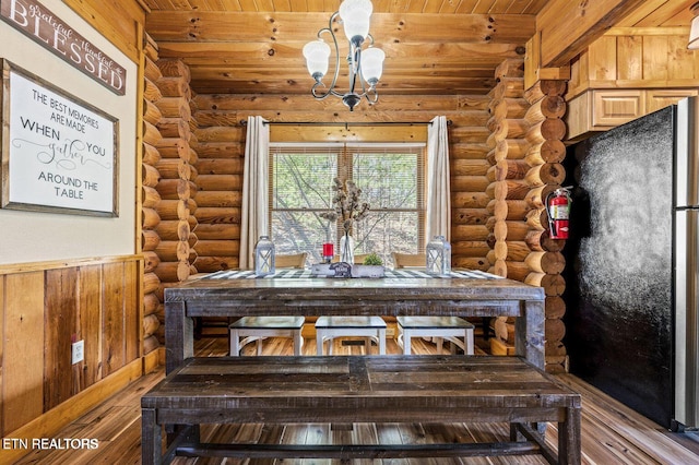 unfurnished dining area with an inviting chandelier, wood ceiling, log walls, and wood finished floors