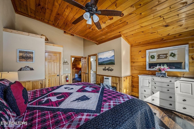 bedroom featuring a wainscoted wall, wooden ceiling, wood finished floors, and wooden walls