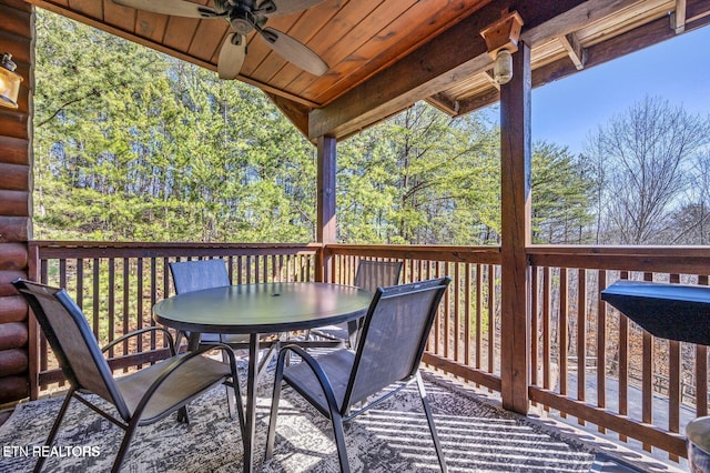 wooden terrace with ceiling fan and outdoor dining space