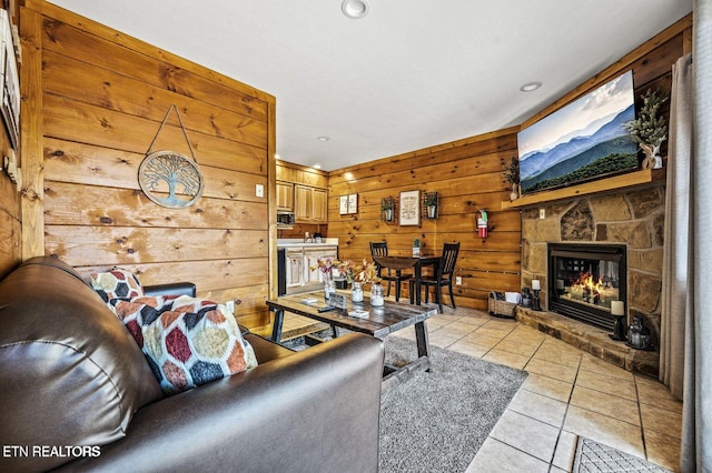 living room with recessed lighting, a fireplace, wood walls, and light tile patterned floors