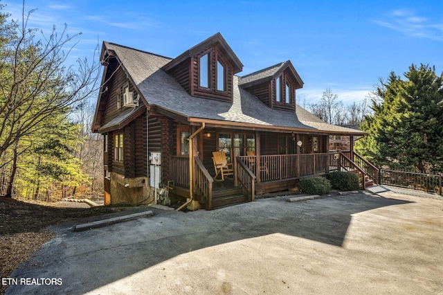 exterior space with log exterior, a porch, and roof with shingles