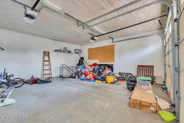 garage featuring a garage door opener and concrete block wall