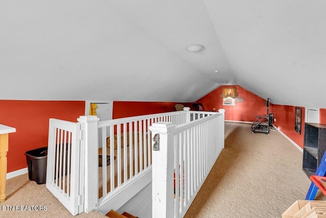 additional living space with vaulted ceiling, carpet flooring, and baseboards