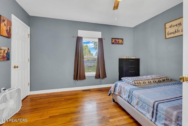 bedroom with visible vents, ceiling fan, baseboards, and wood finished floors