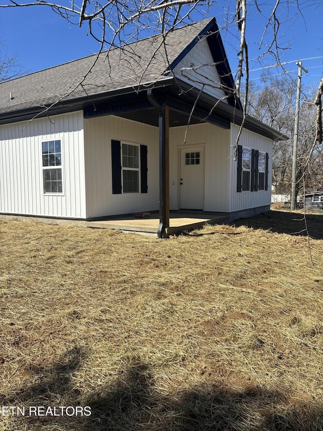 back of house featuring a shingled roof and a patio area