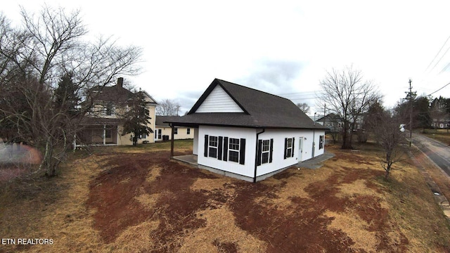 view of side of property with roof with shingles