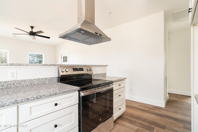 1229 N Main St, Sweetwater, TN 37874 - kitchen featuring ceiling fan, baseboards, wall chimney range hood, stainless steel electric stove, and light wood-type flooring
