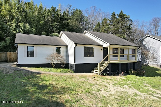 ranch-style home featuring a front lawn and fence