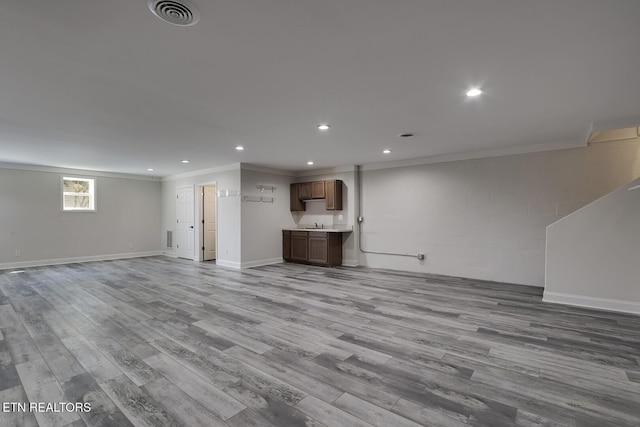 unfurnished living room featuring visible vents, recessed lighting, crown molding, and wood finished floors