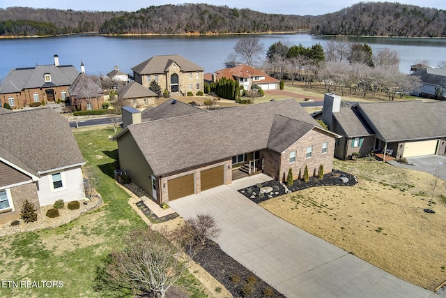 bird's eye view with a water view, a residential view, and a wooded view