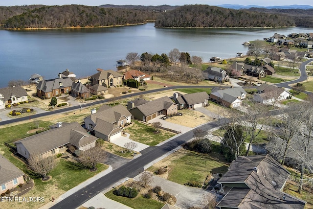 birds eye view of property with a residential view, a wooded view, and a water view