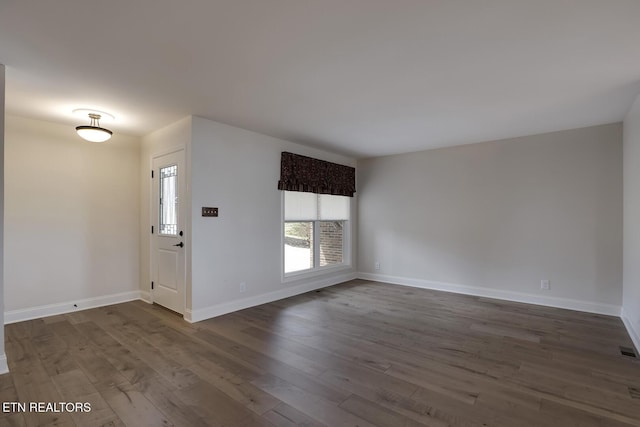 interior space featuring visible vents, baseboards, and dark wood-style floors