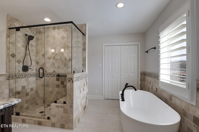 full bathroom featuring tile patterned flooring, a soaking tub, recessed lighting, and a stall shower